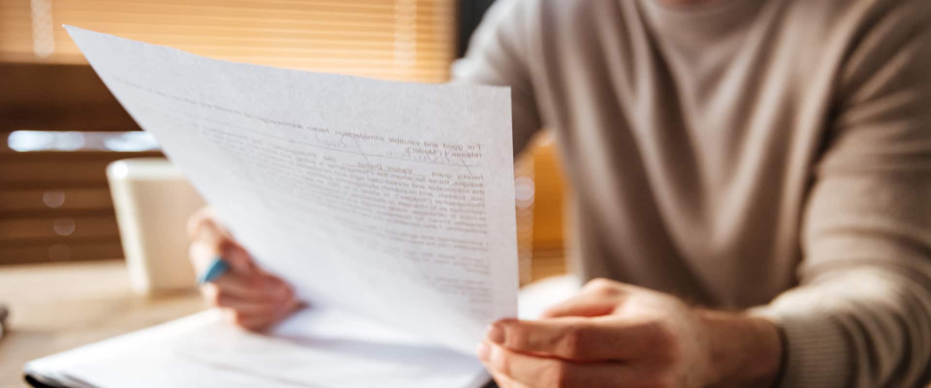 Человек изучает выданное ему свидетельство о праве на наследство от нотариуса