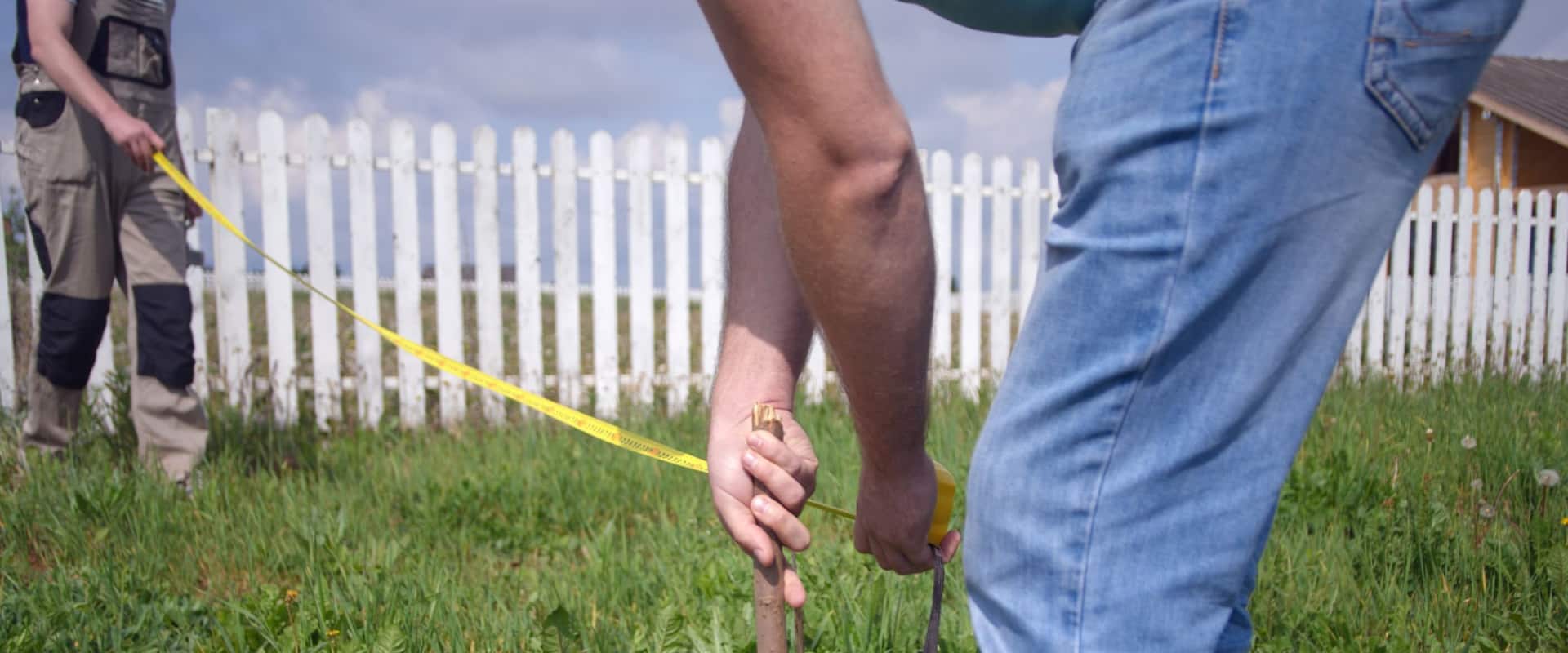 Люди устанавливают колышки, чтобы измерить площадь земельного участка в гектарах