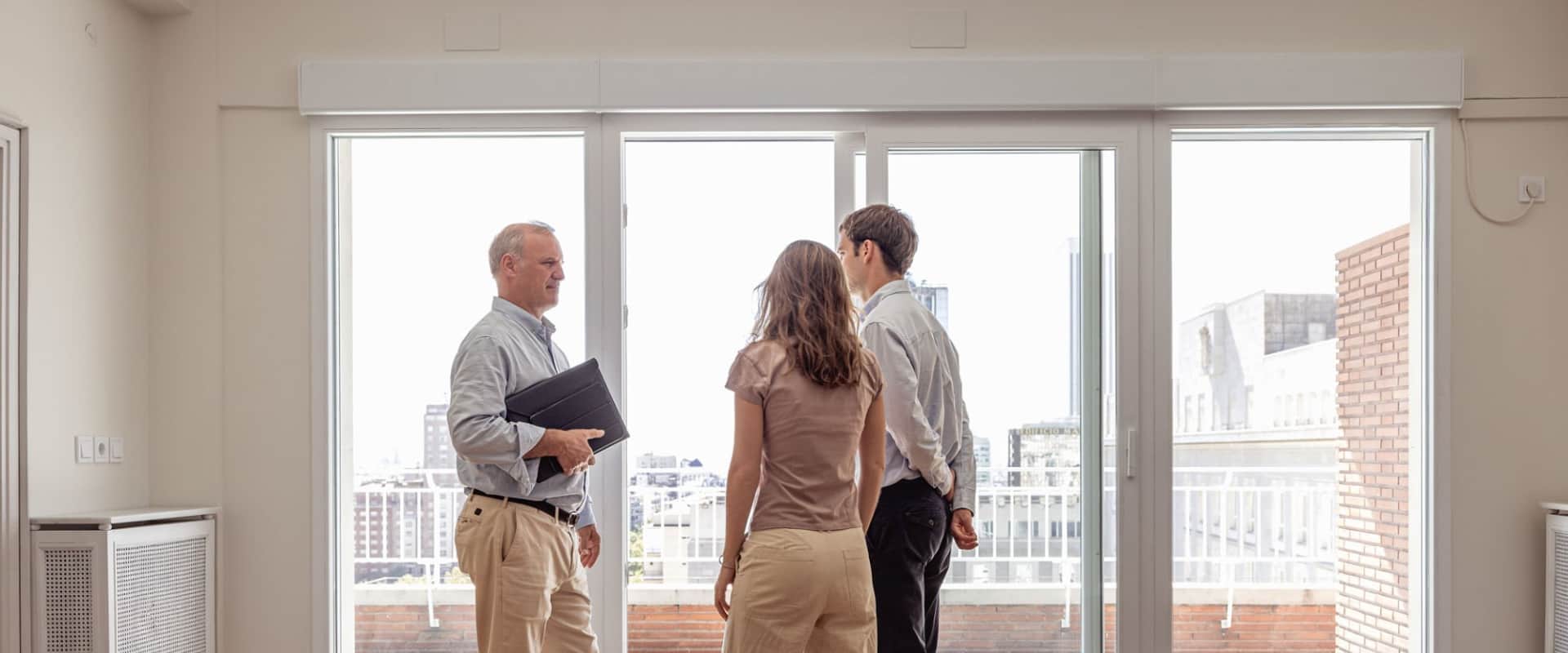 Мужчина показывает квартиру и разговаривает с потенциальными покупателями